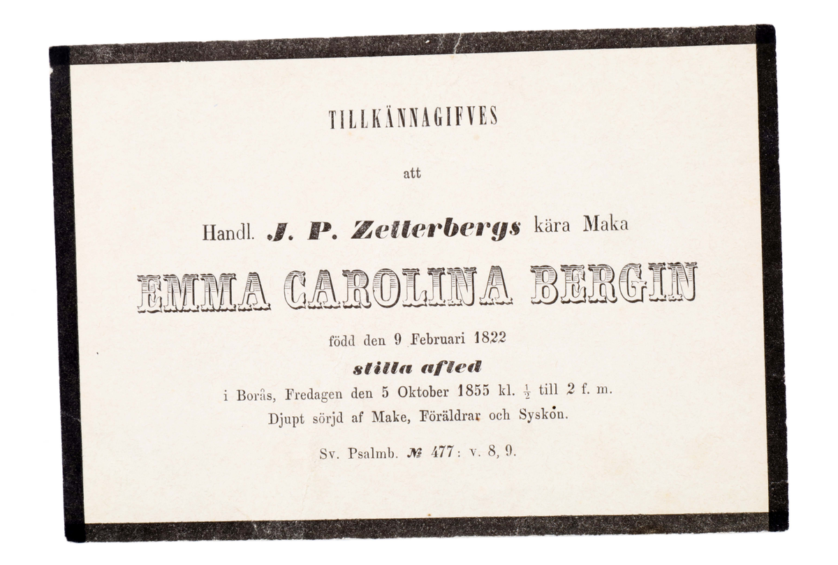 Notifikationskort gällande dödsfall, i beigeblekt papper med svart kant. Tryckt text i svart: "TILLKÄNNAGIFVES att Handl. J. P. Zetterbergs kära Maka EMMA CAROLINA BERGIN född den 9 februari 1822 stilla afled i Borås, Fredagen den 5 Oktober 1855 kl. 1/2 till 2 f. m. Djupt sörjd af make, Föräldrar och Syskon. Sv. psalmb. No 477 : v. 8, 9".