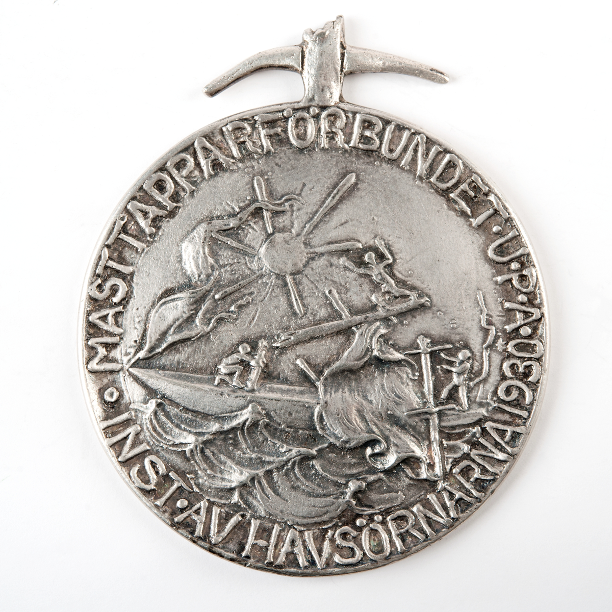 Åtsidan avbildar ett masthaveri. Frånsidan namnet inristat på avbruten maststump. Medaljen kröns av bruten mast med krökta rår.