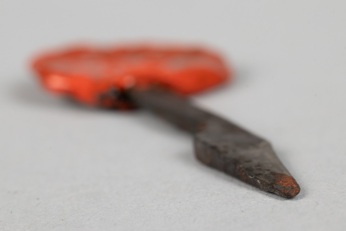 Pennekniv i metall med et segl i rød lakk festet på skaftet