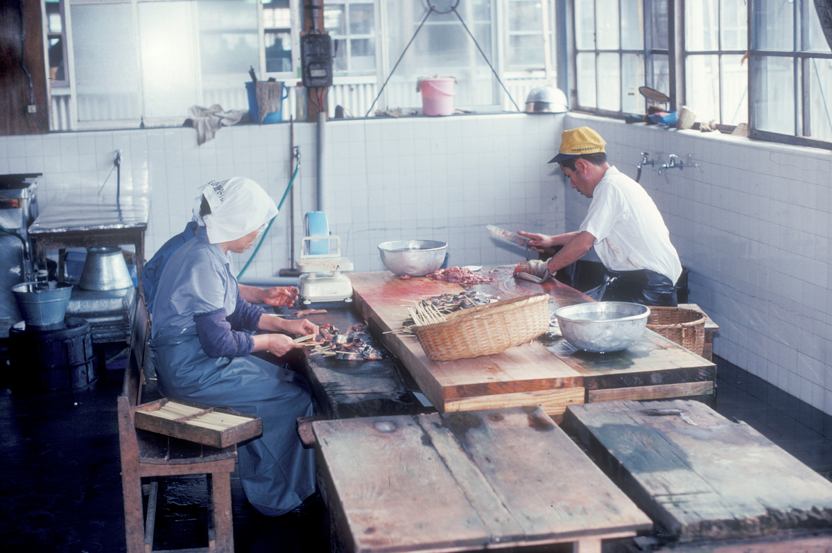 Motiv fra Japantur : Filetering av sjømat, 2 kvinner og 1 mann jobber