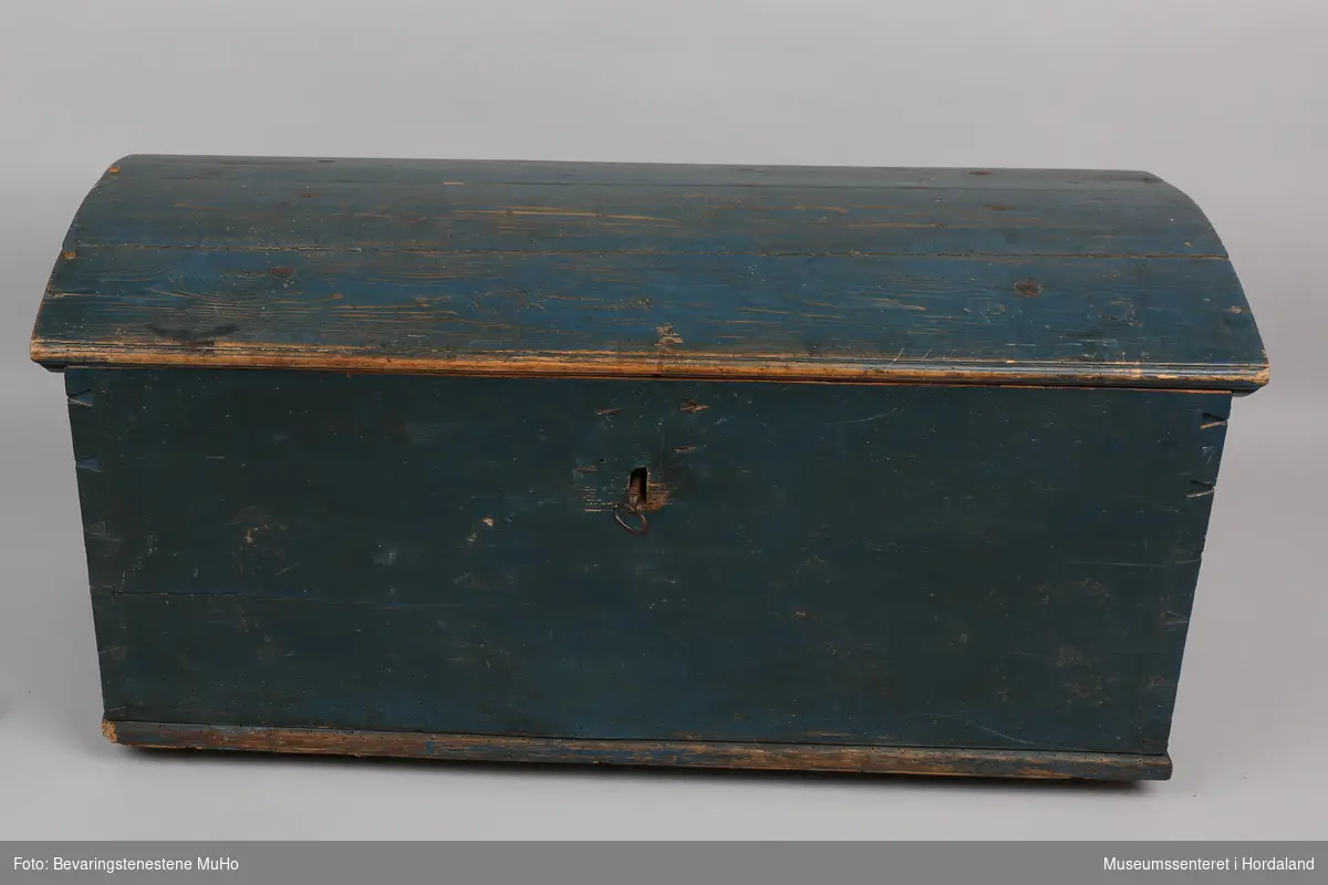 Blåmalt kiste av tre med svakt buet lokk. Innvendig er en leddik på venstre side. Kista har tilhørende nøkkel.