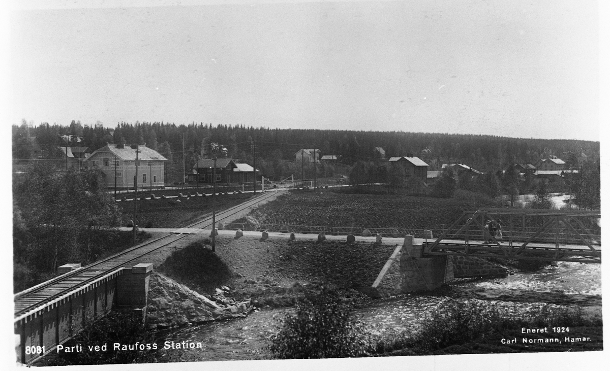 Postkort med motiv fra Raufoss. Bildet er tatt fra "Smedshammer" mot Sydøst. Bygningen til venstre er Raufoss stasjon..