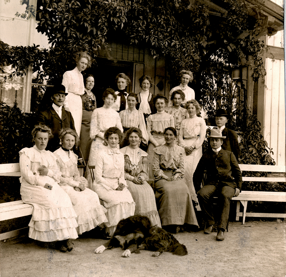 Gruppebilde, kvinner og menn i prestegaarden på Hov, Kongsvinger 1904.
Bilde er fra fotoalbum GM.036887.