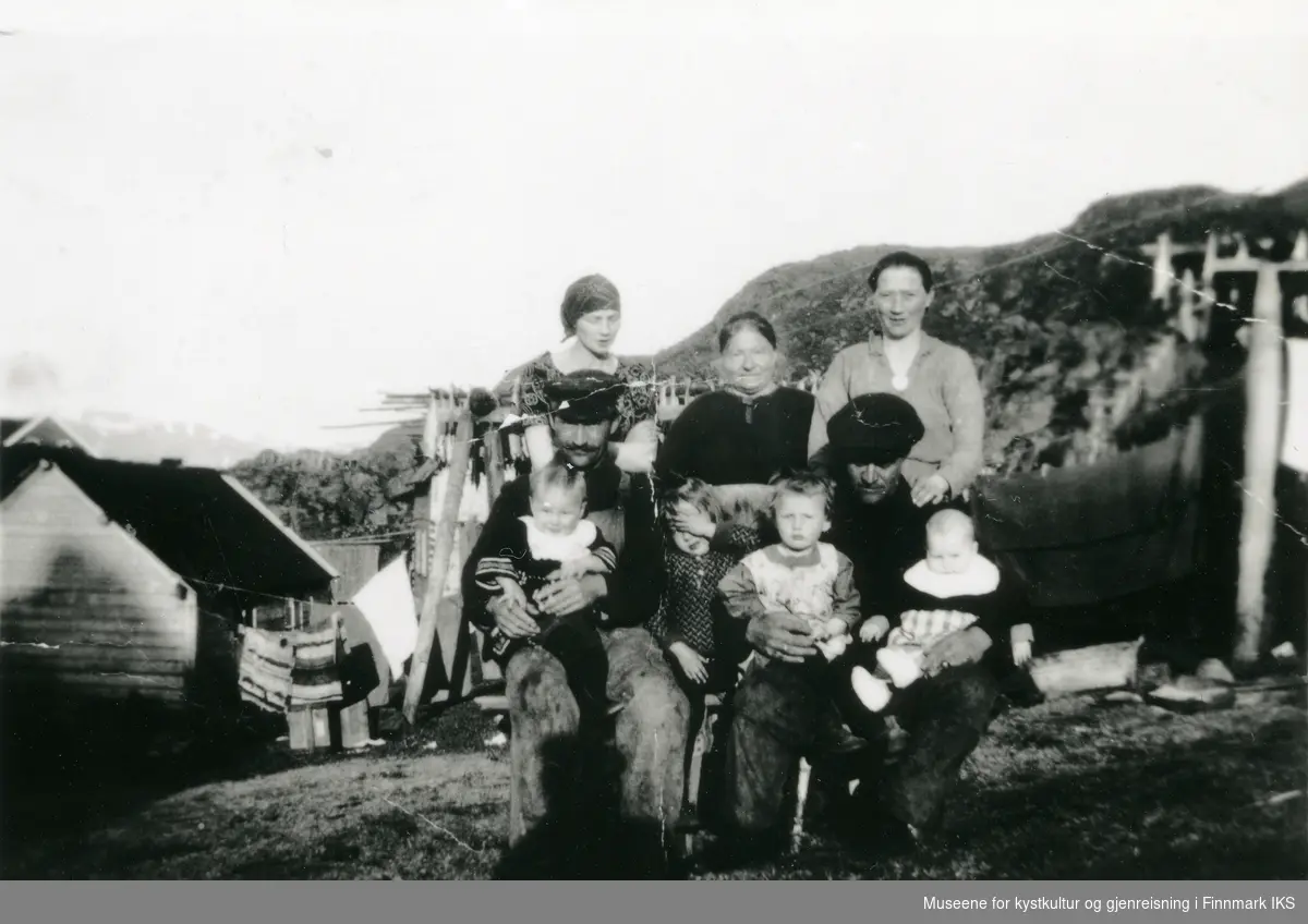 Gruppebilde i Kamøyvær. I bakgrunnen ser man deler av bebyggelsen og klesvask. 1926.