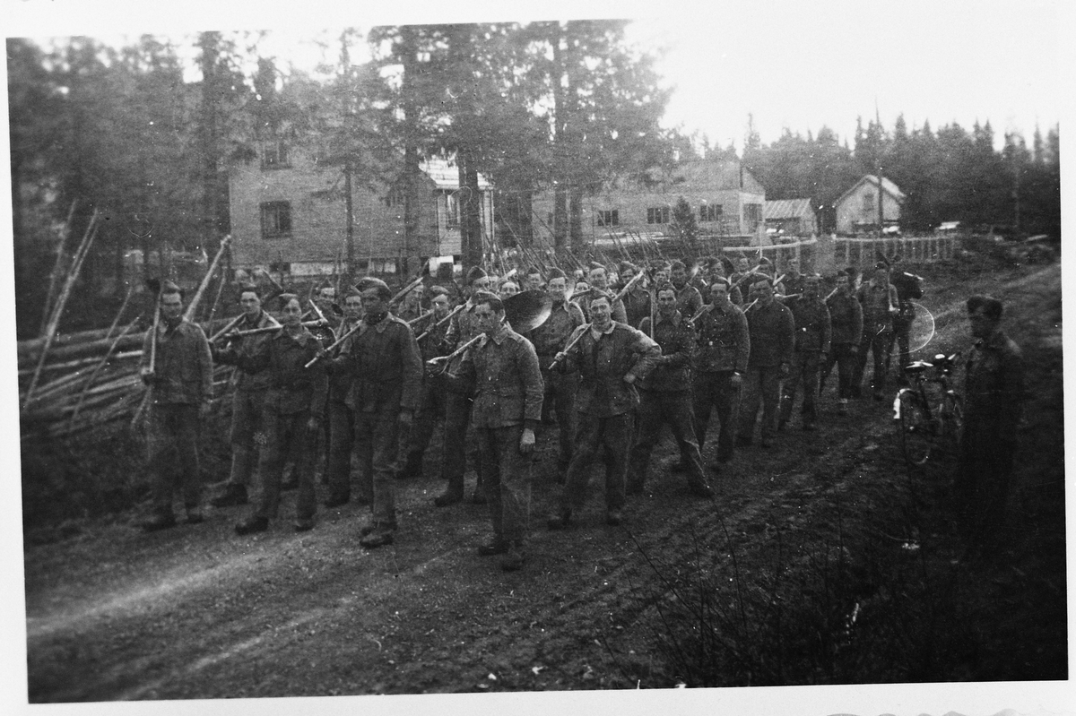 Antatt mannskaper fra Arbeidstjenesten (AT) på marsj langs veg et sted i Vestre Toten.