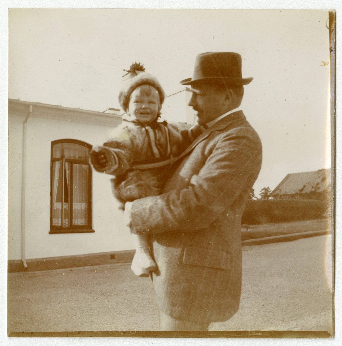 Foto av mann med barn i ermene. Antagelig er barnet Nils Frederik Aall og mannen hans far, Cato Aall