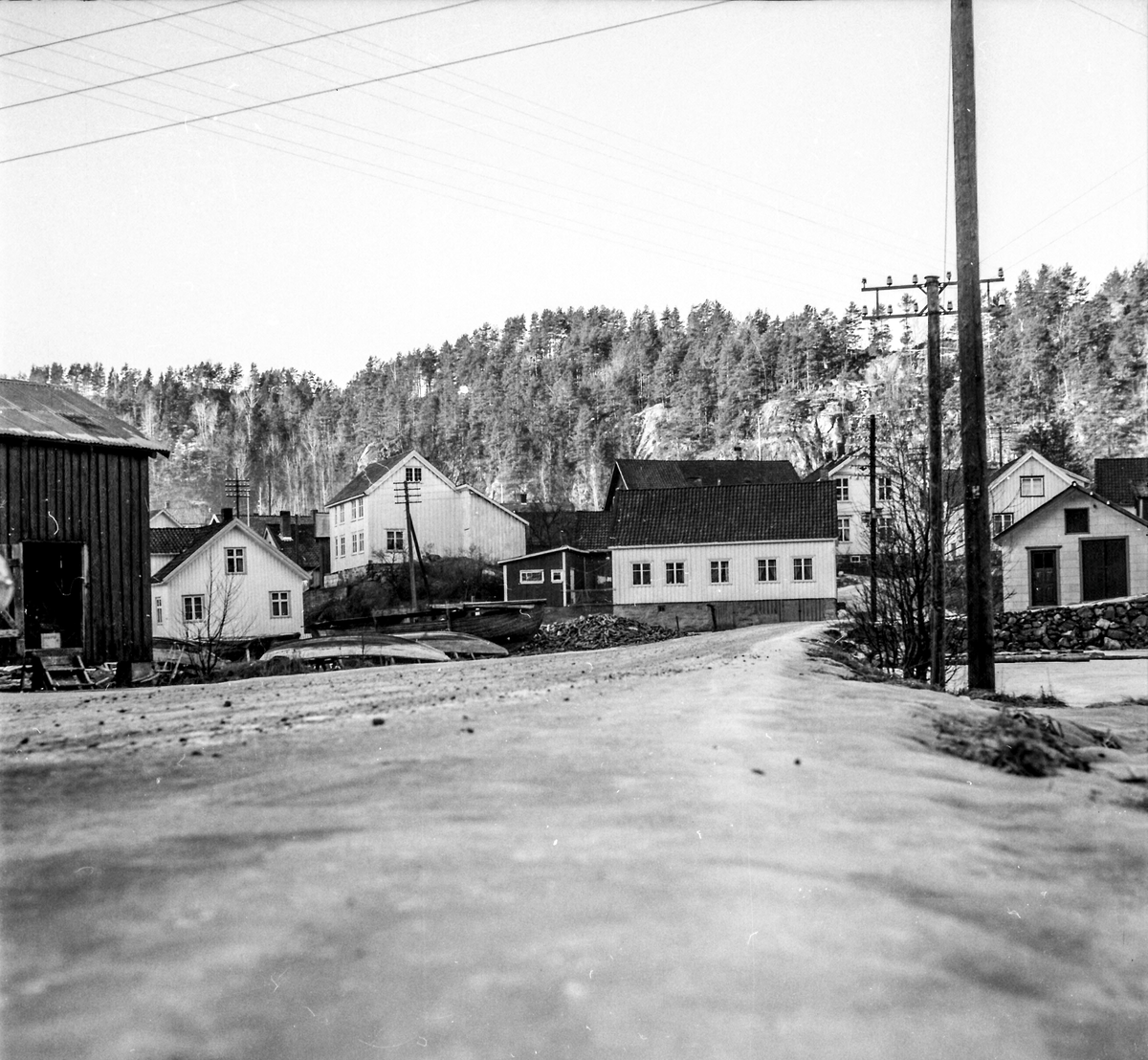 Bebyggelse nederst i Kil. Til venstre,  "Drangedalsbua"hvor varer som kom med båt og skulle videre til Drangedal ble oppbevart. Eier  Jacob Menstad brukte den siden som lager til  hodekål og blomkål. 1960-70