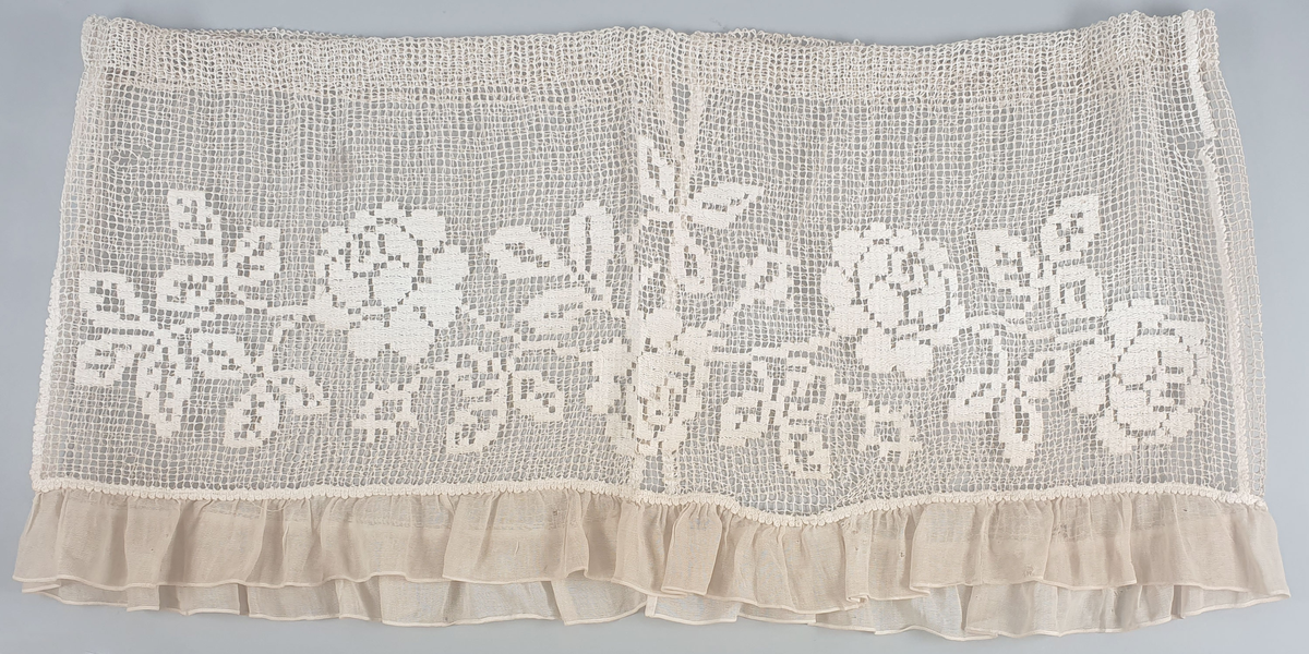 To like gardiner med broderte blomster på netting. Folder langs den nederst kanten.