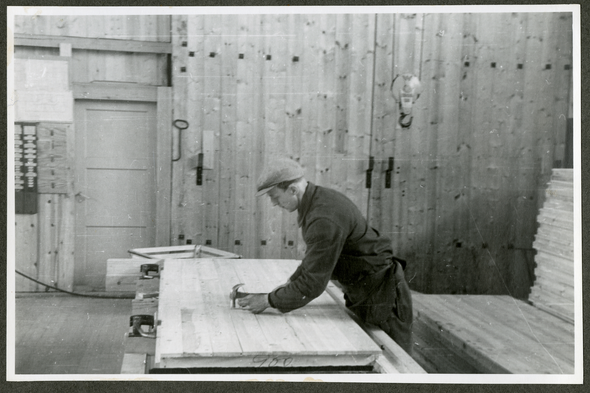 Foto av mann som jobber med tremateriale på Aall-Ulefoss Brugs Dørfabrikk