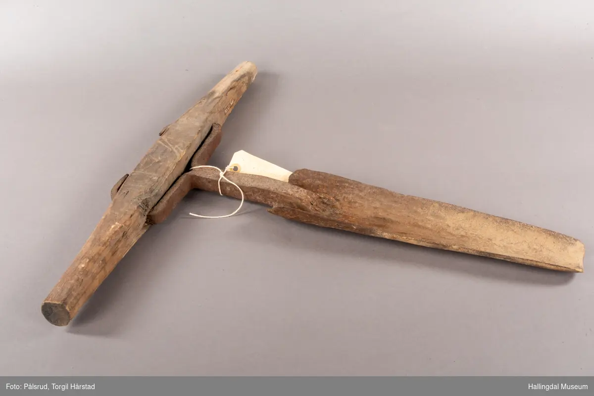 Smal rundet "spade" med kraftig tverrgående håndtak av tre.