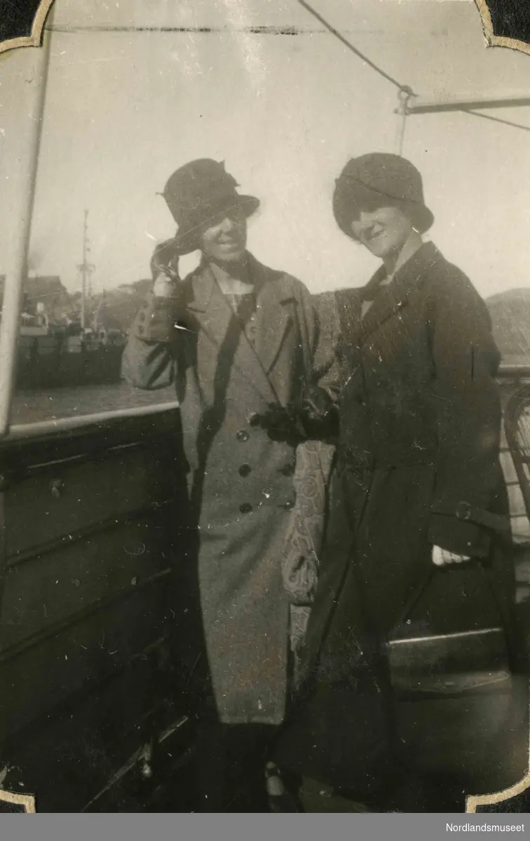 To kvinner med hatt og kåpe ombord i et skip. Karen Kvam og Klara Simonsen (gift Hunstad) ombord i Hurtigruta, 1925.
