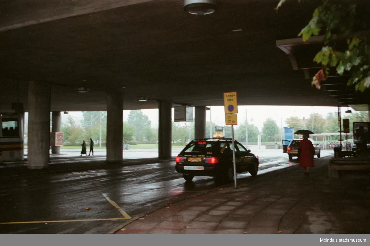 Taxizon och taxibilar under bron. Mölndalsbro i dag - ett skolpedagogiskt dokumentationsprojekt på Mölndals museum under oktober 1996. 1996_1190-1211 är gjorda av högstadieelever från Kvarnbyskolan 9D, grupp 4. Se även 1996_0913-0940.