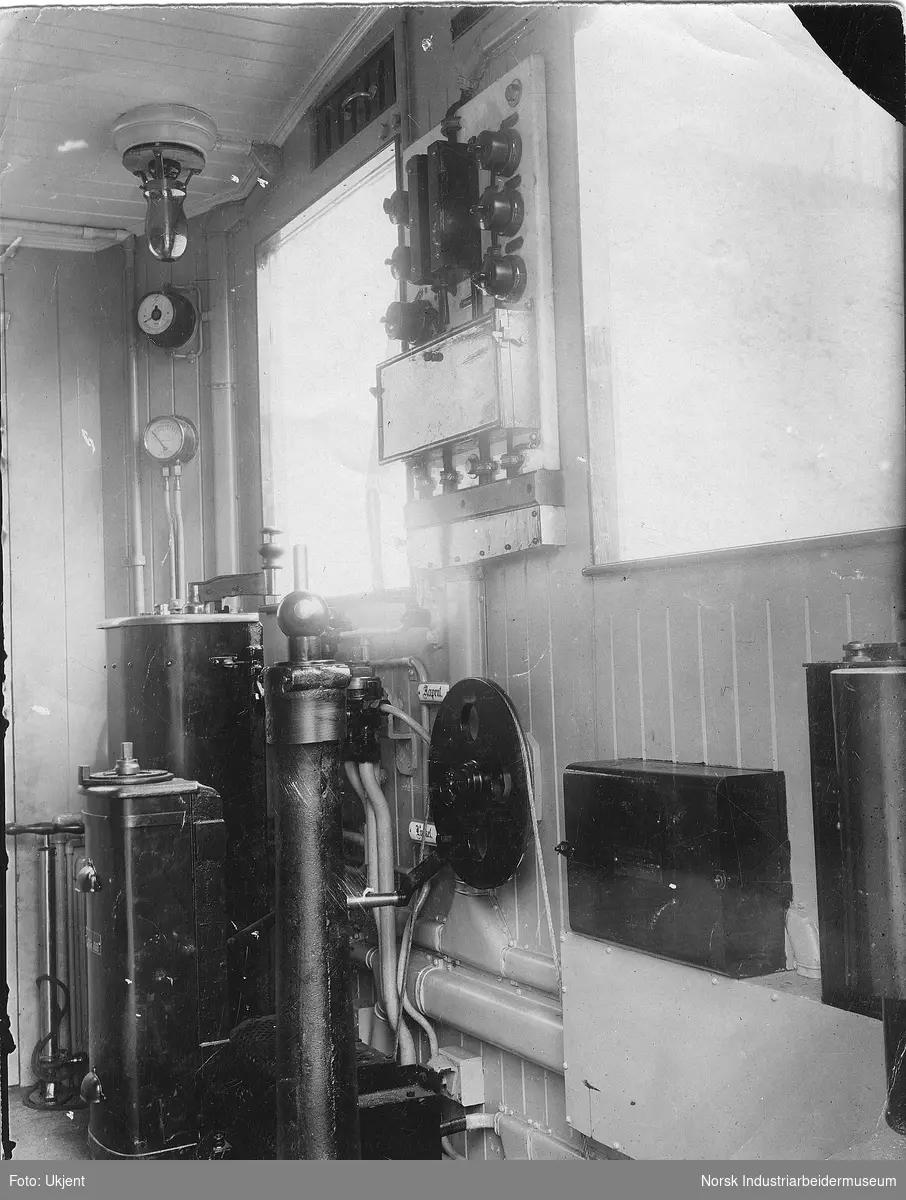 Førerhytta i elektrisk lokomotiv R.B 1 fra 1911. Instrumenter montert på vegg mellom og under vinduer.