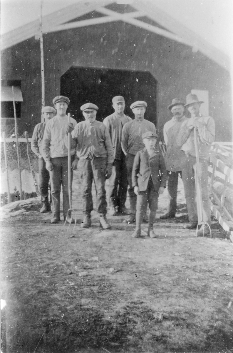 Gruppebilde utenfor låven på Hunstad, under tresking på høsten. Ca. 1918.