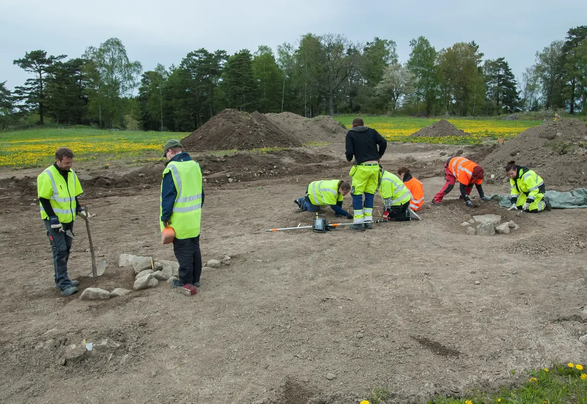 Arkeologisk forskningsgrävning av gravgården vid Broby bro Raä 42. Arkeologerna Richard Grönwall (t.v.), Lars Andersson (mitten) samt Jennifer Shutzberg (t.h.), samtliga från Stockholms läns museum samt studenter från Stockholms universitet