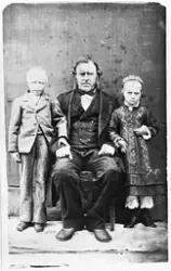 Portrett av en voksen mann og to barn. Personene er Paul And