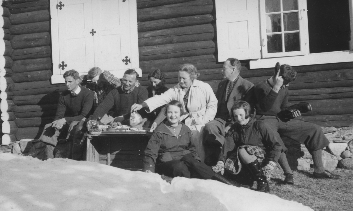 Familien Simonsen med påskegjestrer er samlet i solveggen ved hytta Svartvik