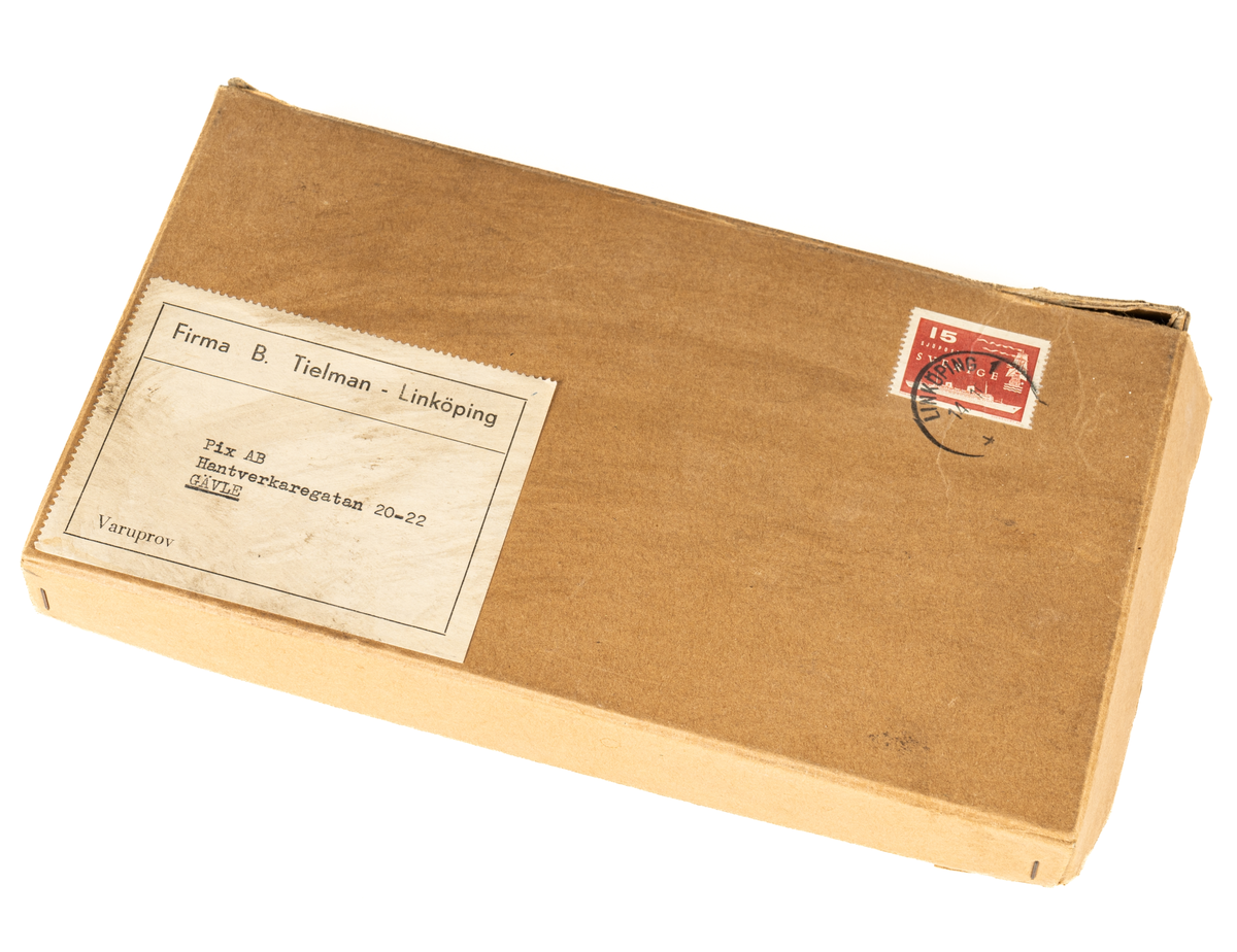 Frankerat paket i brun papp med frimärke och adresslapp från firma B. Tielman i Linköping till Pix AB i Gävle. Paketet innehåller varuprover på pappers- och aluminiumformar i olika färger till knäck och andra sötsaker. Tillhörande brev med förslag på försäljning från firma B. Thielman.