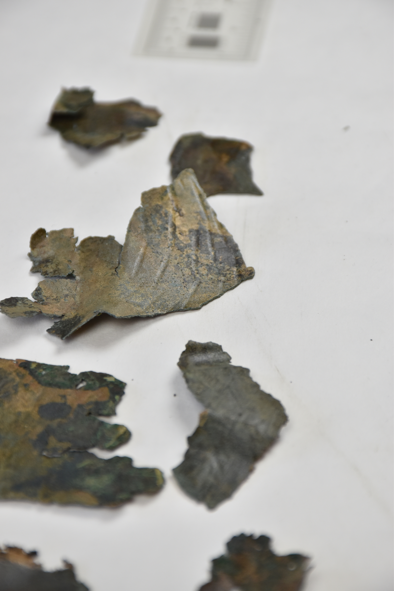 Sköldfragment, 44 st., med rester av ornamentik i form av vulster och bucklor.