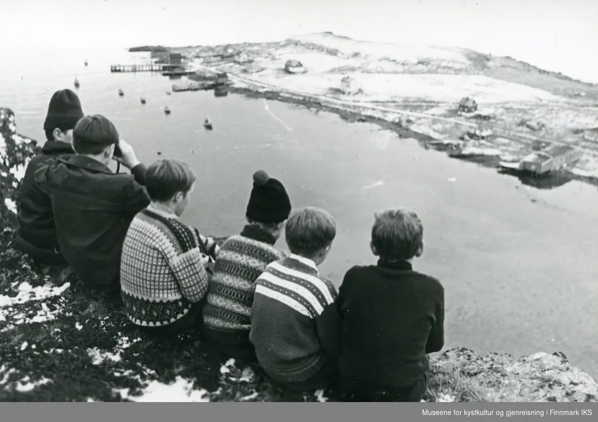 Sarnes. Oversiktsbilde med deler av bebyggelsen. En gruppe gutter fra Solvang internatet sitter på fjellet. En har med seg kikkert. 1963-1970.