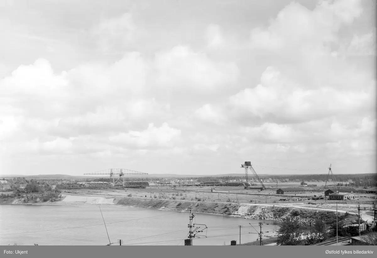 Kran for opptak av sagtømmer og tømmerlager og luftbane til Borregaard fabrikker, Opsund i Sarpsborg 1945. Bildet viser at det var sparsomme tømmerlager under 2. verdenskrig.