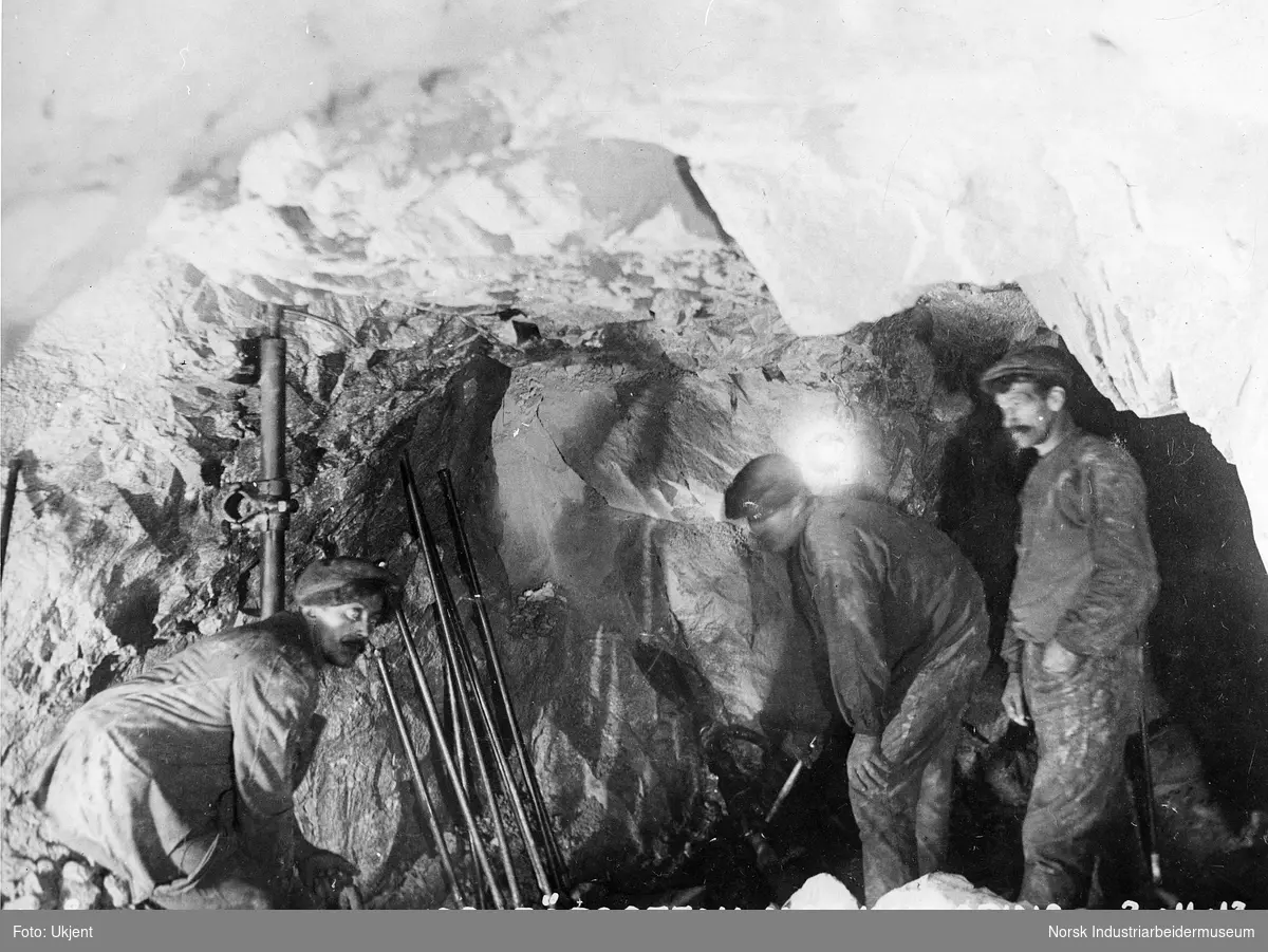 Tre anleggsarbeidere under arbeid med å bore ut tunell for rørgaten til Såheim Kraftanlegg.