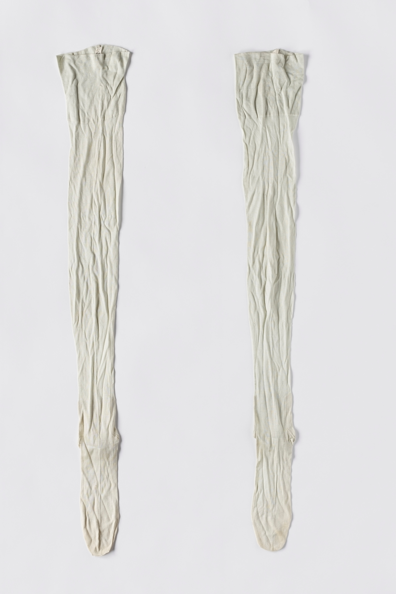 Strikkede turkise strømper i kunstsilke (viskose). Foten er formsydd. Det er strikket hullmønster fra hælen og oppover ankelen.
