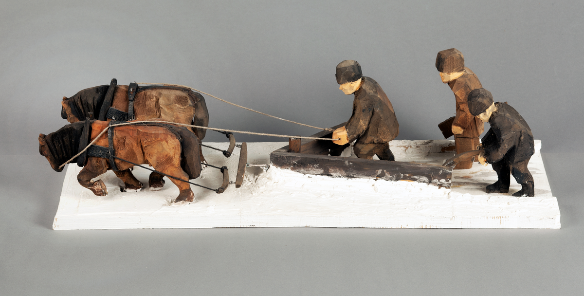 Skulptur av trä. "Snöplogning", tillverkad av Hans Lustig.

Skulpturen framställer två hästar dragande en V - formad snöplog, en man kör hästarna, den andra för plogen och den tredje bär en snöskovel. Hela gruppen står på en platta.