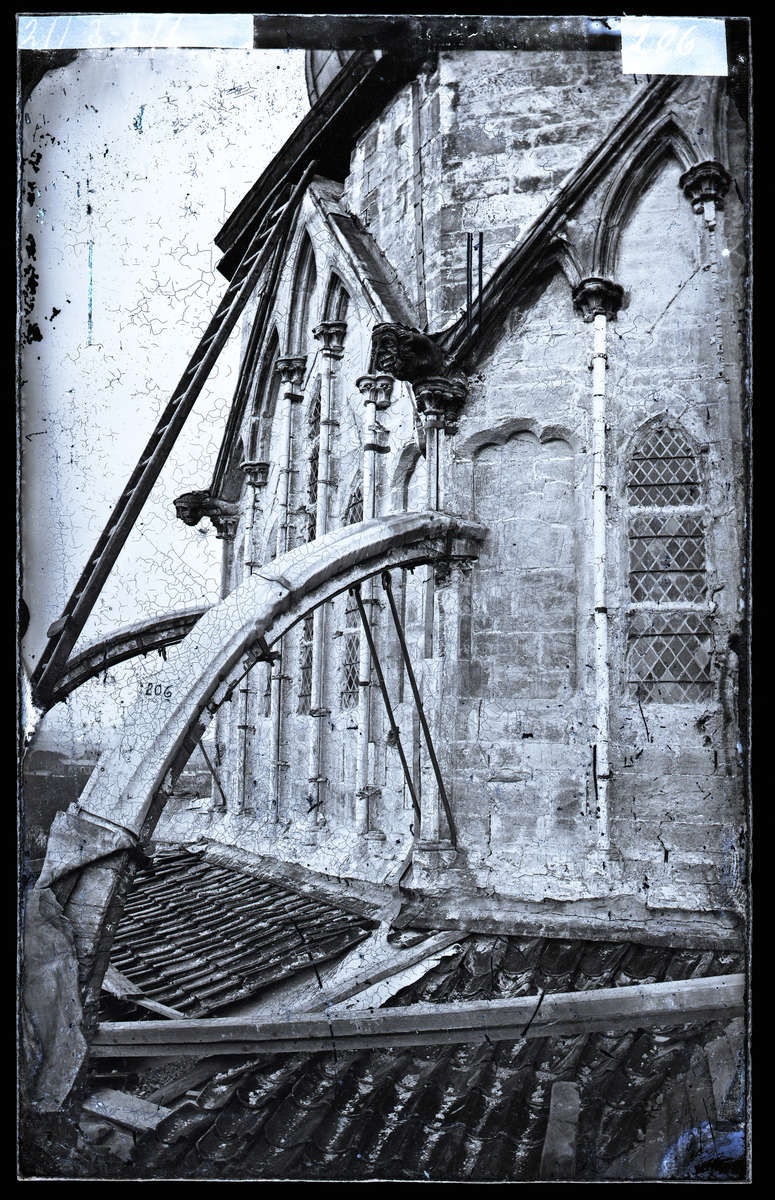 Oktogonen i Nidarosdomen. Veggparti mot øst, i klerestoriehøyde. Strebebuer og gotisk skulptur. Gamle blyglassvindu. Til venstre i bildet en stige i tre. I følge Hovedkatalog over fotografier er bildet tatt før restaurering. Oktogonen ble restaurert i perioden 1872-1877.
