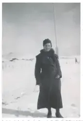 En kvinne i vinterklær står ute i snøen og smiler til kamera