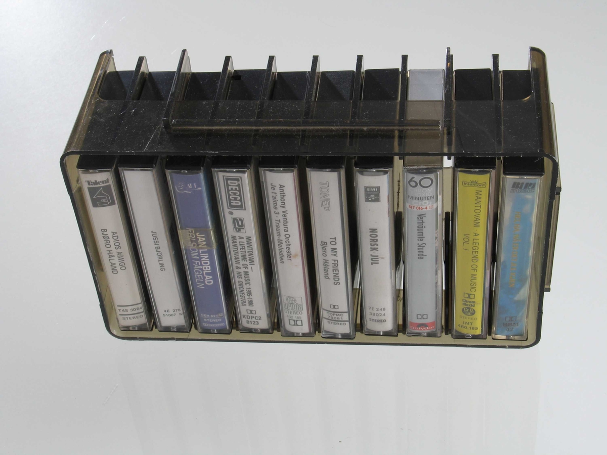 Form: Rektangulær kasse med avrunda hjørner, med plass til 10 kassetter
