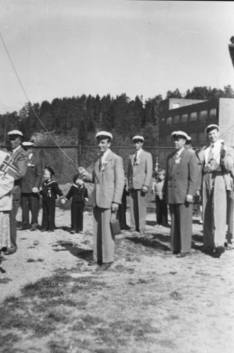 Medlemmer av Oppegård mannskor stående oppmarsjert foran gjerde.