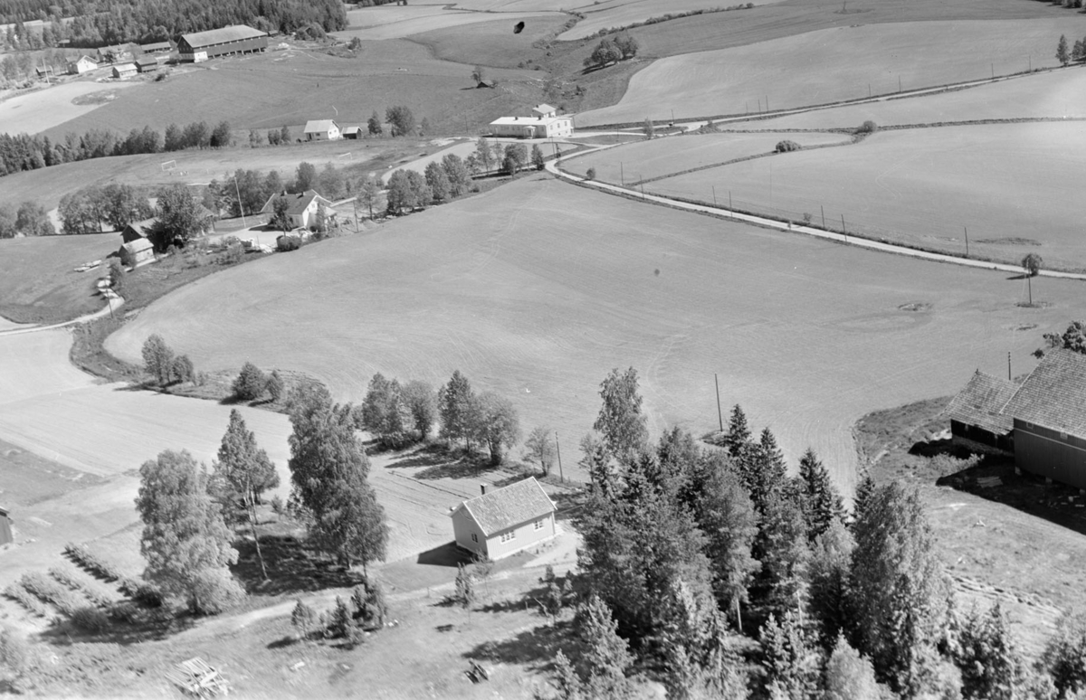 Vollholen med Kroer skole og samfunnshus bak i bildet. litt av gårdene Sutterhol til venstre og Moer til høyre foran