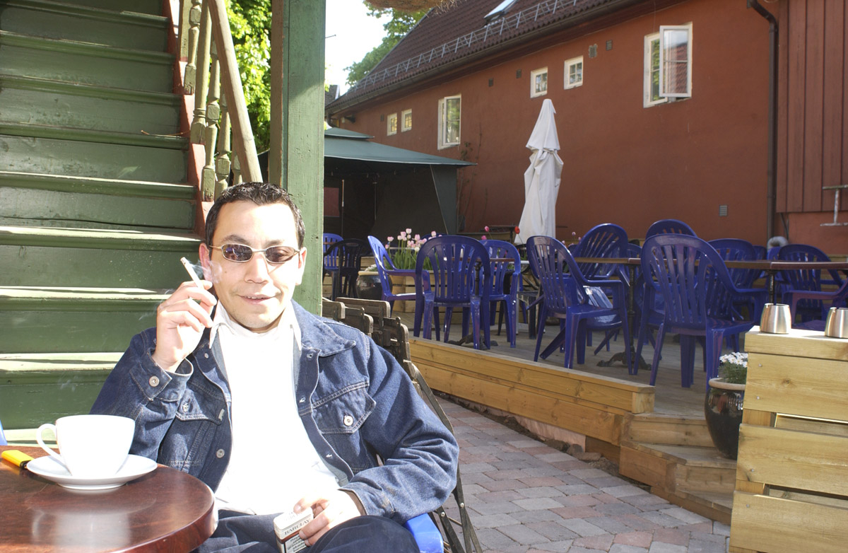 Pubgjest sitter ved et bord med røyk og kaffe i bakgården Milde Moses Pub & Spiseri i Drøbak