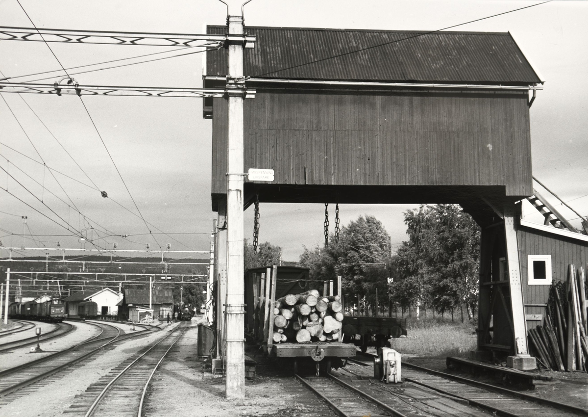 Skifting med lok 7 Prydz og El.10.2511 på Sørumsand stasjon.  Tømmervogn klar for omlasting under portalkranen.