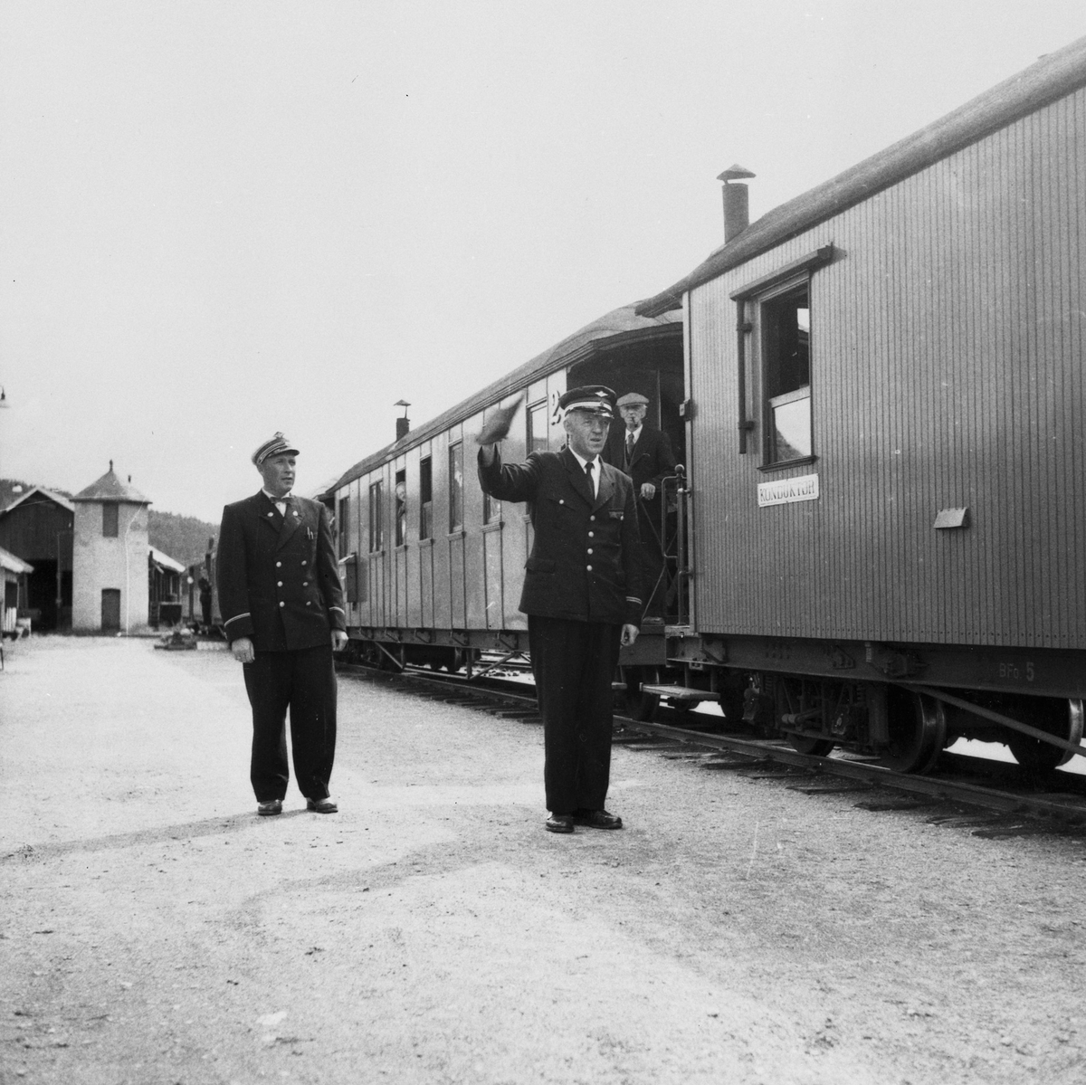 Tog retning Sørumsand. Overkonduktør  Håkon Kjeldsrud (t.h) gir avgangssignal etter at togekspeditør Emil Hansen har gitt avgangsordre.