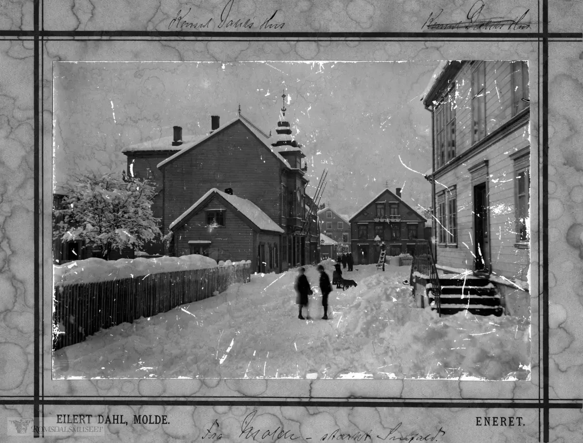 Storgata sett vestover., Storgata i Molde ca 1895, til venstre med tårn N.P Dahls. .Det lille enetasjers huset til venstre i forgrunnen er T.J Owren sin butikkbygning. .Det lille enetasjers huset i bakgrunnen er (Caffe) kaffe-Guris hus. (Guri Oppsahl). ca 1895.Hus nr 79 i Molde (Owren) Slakter O.G.Steen nærmest på venstre side..