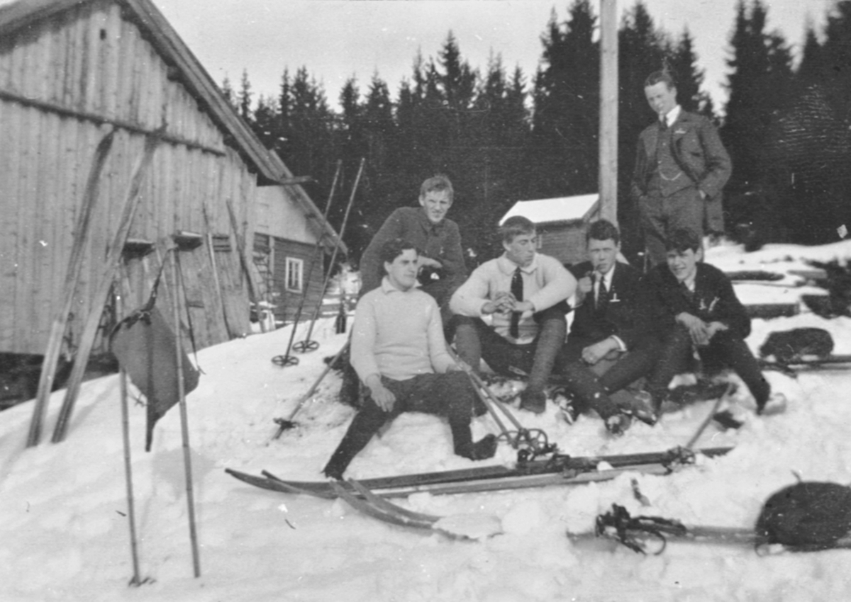 Seks unge på skitur. Pause ved hytte.