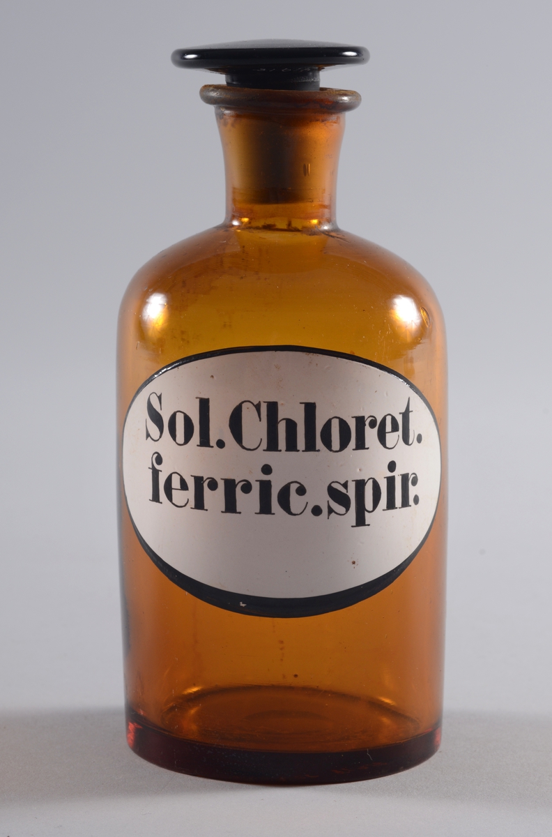 Flaske
Brunt glass med slepen,flat propp.
Oval etikett med svart skrift.
 