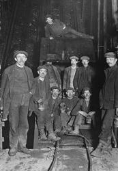 En gruppe gruvearbeidere avbildet foran heisen i Fearnley sj