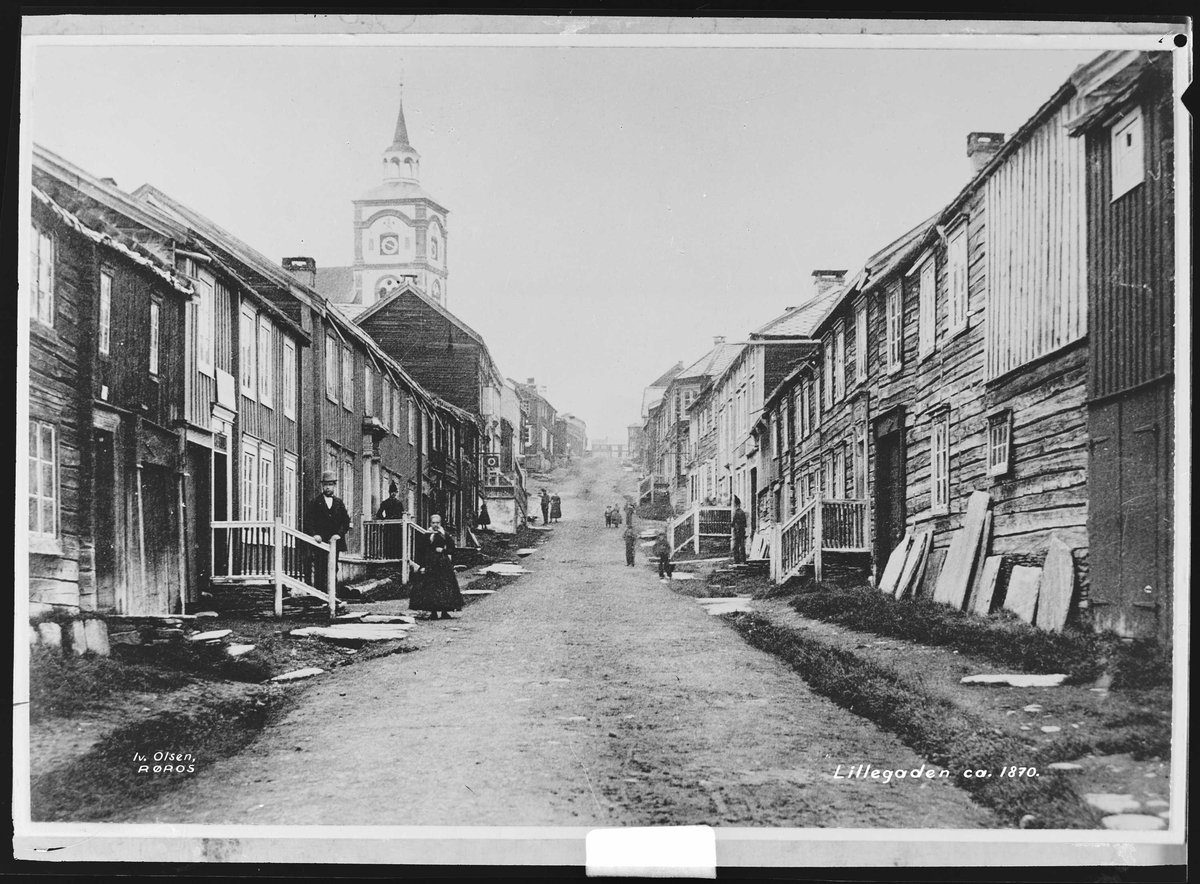 Kjerkgata på Røros rundt 1870. Bebyggelse på begge sider av gata sett oppover mot kjerka.