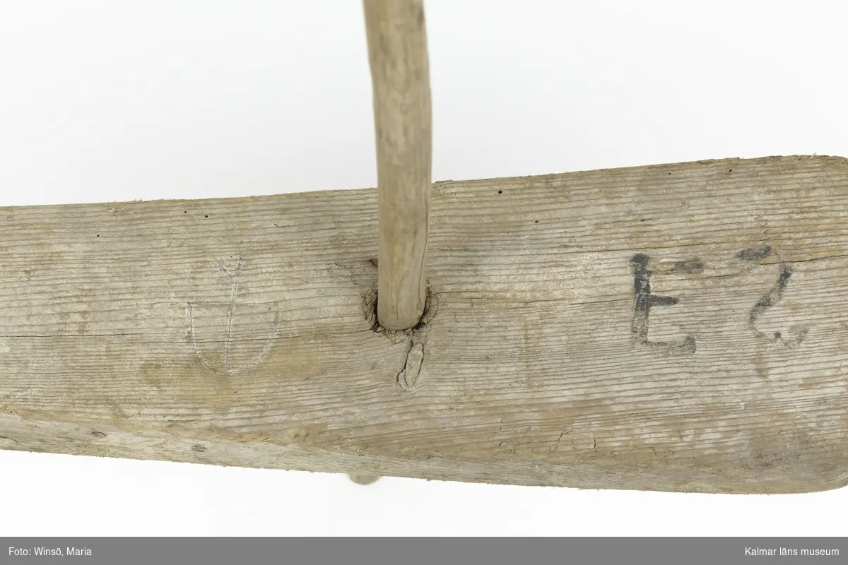KLM 24310. Vakare, våle, trä. Flytande föremål som användes för att markera en plats i vattnet, exempelvis nät. Stycke av trä med pinne. Bomärke samt märkt med initialerna "ES" (Edvard Simonsson).
