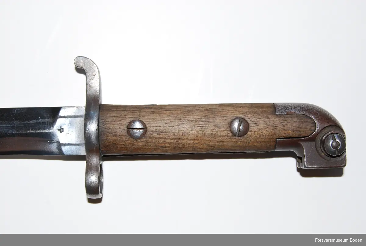 Typen användes till karbin m/1894-1914 och kulsprutepistol m/1945C. Tveggead klinga försedd med stämpel för Carl Gustav gevärsmanufakteri. Grepplattor av trä fastsatta med skruvar. Baljan försedd med doppsko stämplad med krona. Låsknapp för baljan invid parerstången.