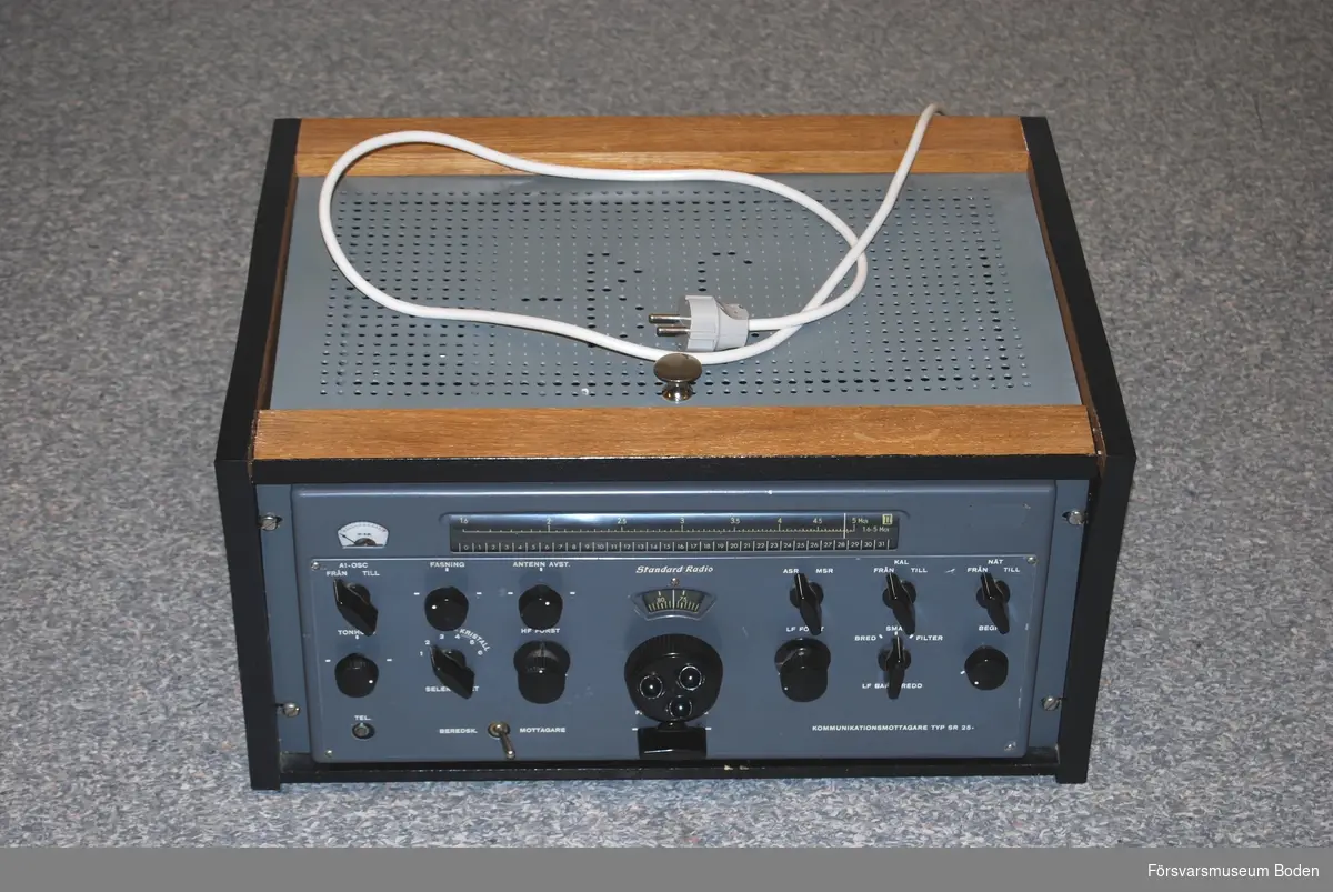 16-rörs radiomottagare av superheterodyntyp med sex frekvensband mellan 0,52-30 MHz. Monterad i trähölje 52,5 x 26 x 38 cm. Serienr 126959. Kopierad manual daterad juni 1956 finns i medföljande pärm.