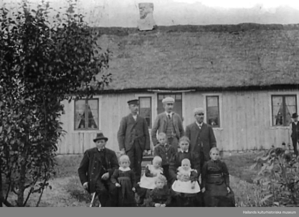 Gruppbild av familjerna Brodd och Larsson som var fiskare och småbrukare. Bostaden som har halmtak tillhör Per Larsson. Kristina Larsson var en sk "skävergumma".