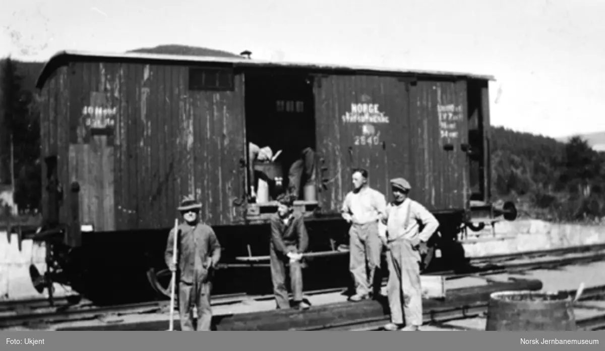 Fire banearbeidere foran godsvogn litra Gf nr. 2640