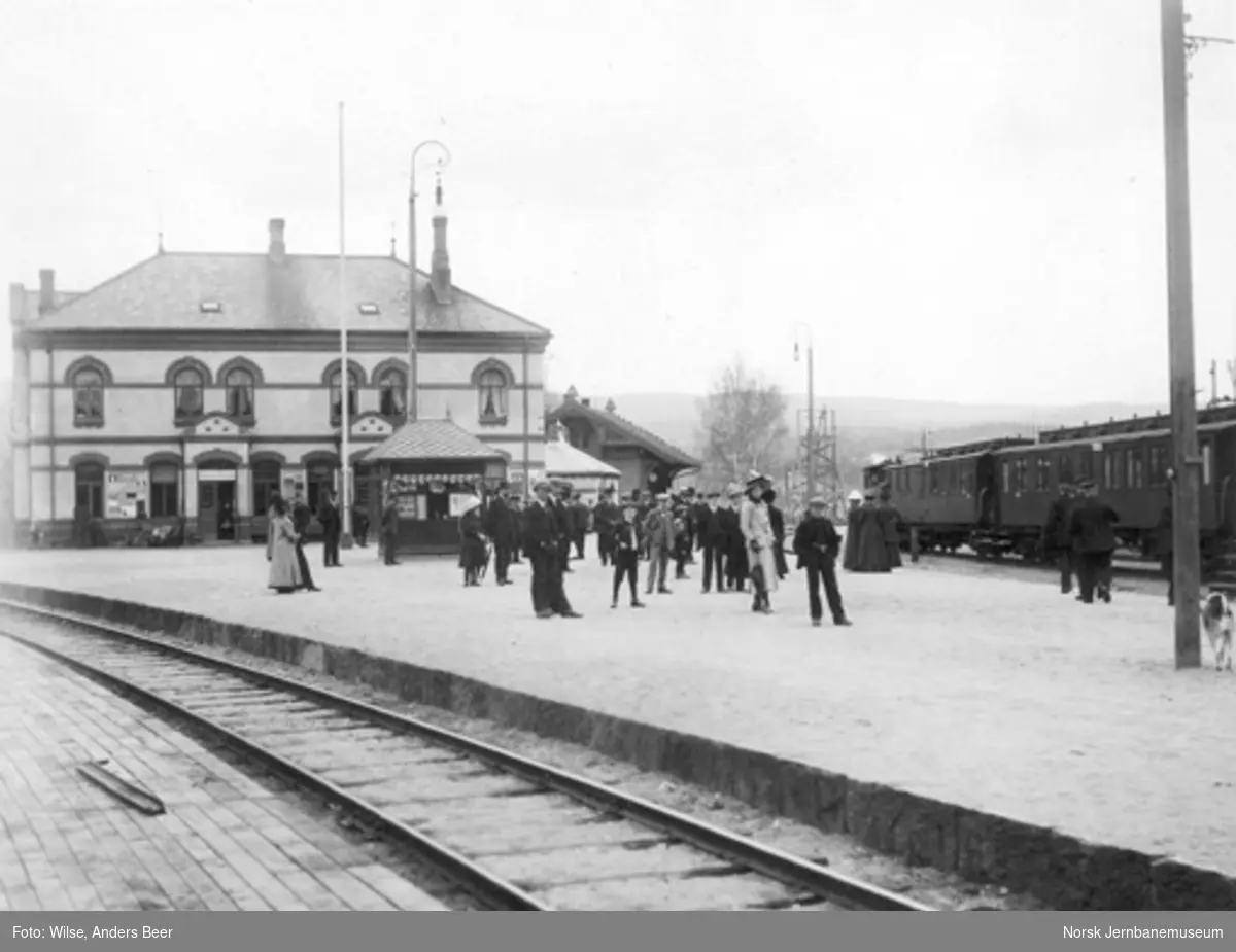 Hønefoss stasjon med toget til Drammen; reisende på plattformen