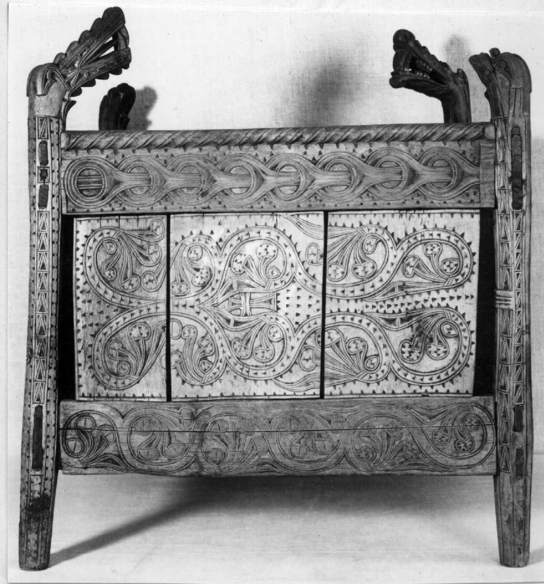 Fire søyler med skåret dyrehode-ornamentikk, sammenføyet med tverrbord og fyllinger. Bunn er åpen foruten to tverrstaver. Hele utsiden er rikt dekorert med utskåret dyr og ranker.