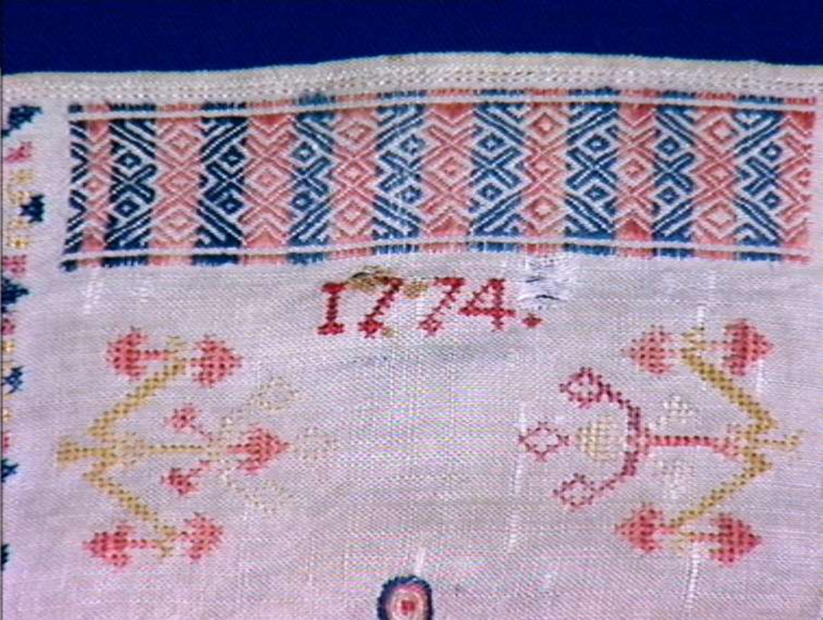 Brodert halsduk til man. 
Flerfarget broderi med år 1774 og monogram.