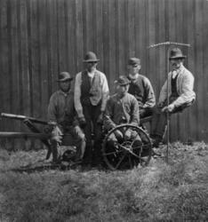 Slåmaskin, Dal gård, Ullensaker. 5 arbeidsfolk poserer foran